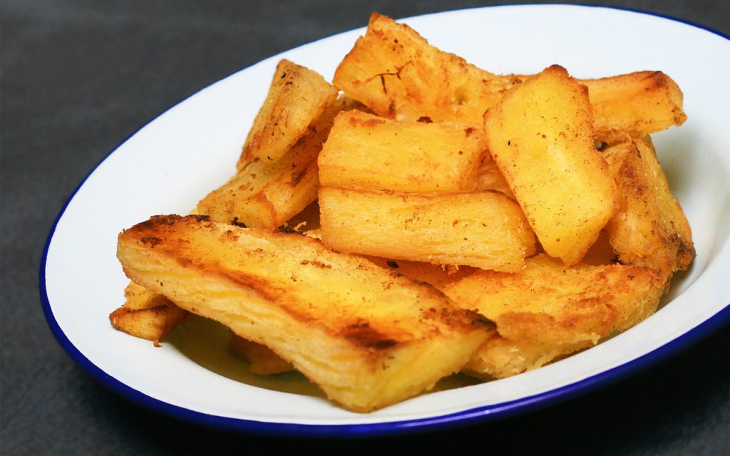 Yuca frita (deep-fried cassava/yuca fries) on a white plate.