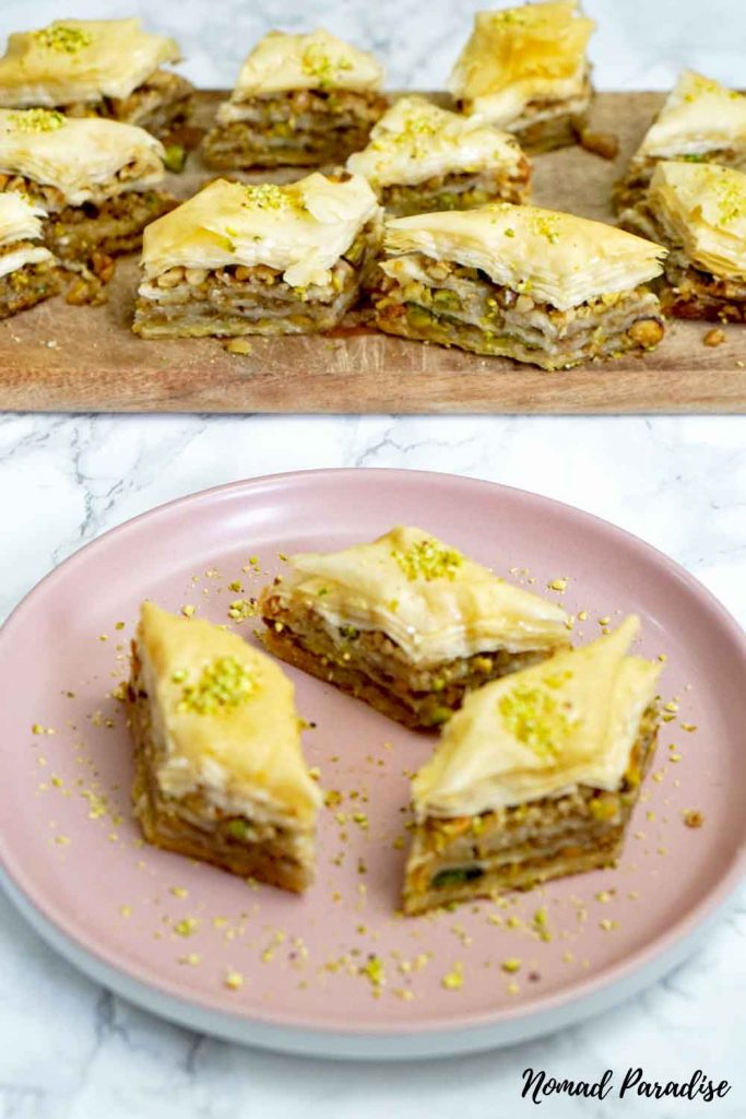 Baklava served on a wooden board and on a small plate.