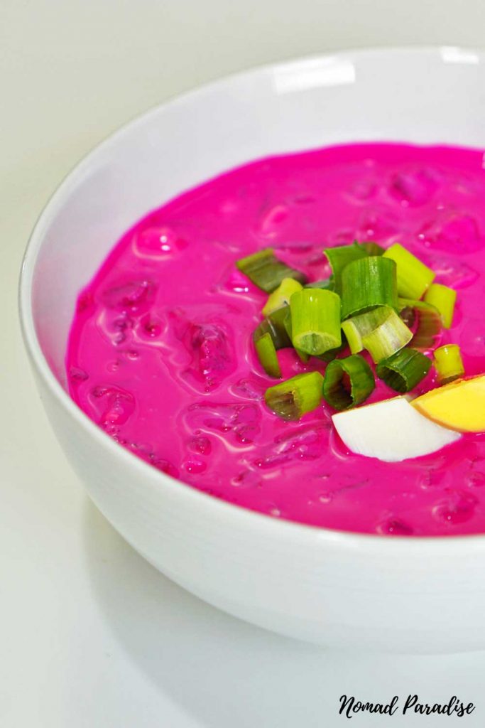 Cold beetroot soup topped with boiled egg and chopped green onions.