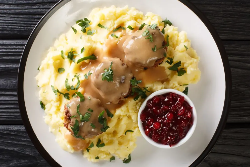 Lihapullat (Finnish Meatballs) with mashed potatoes, brown sauce, and lingonberry jam.