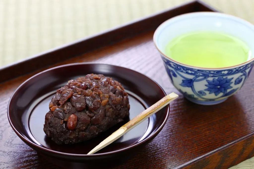 Botamochi (Sweet Rice Balls) and a cup of tea on a wooden tray.