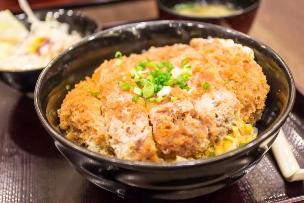 A bowl of katsu don (deep-fried pork cutlet on top of a rice bowl).