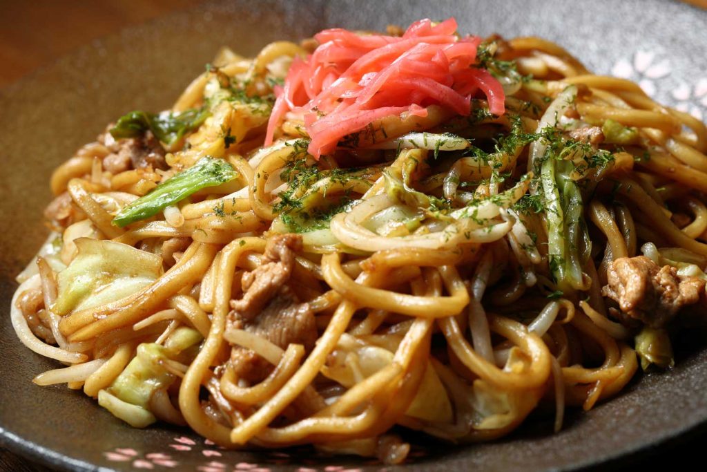 Yakisoba (Japanese stir-fry noodles in a bowl, topped with some pickled ginger).