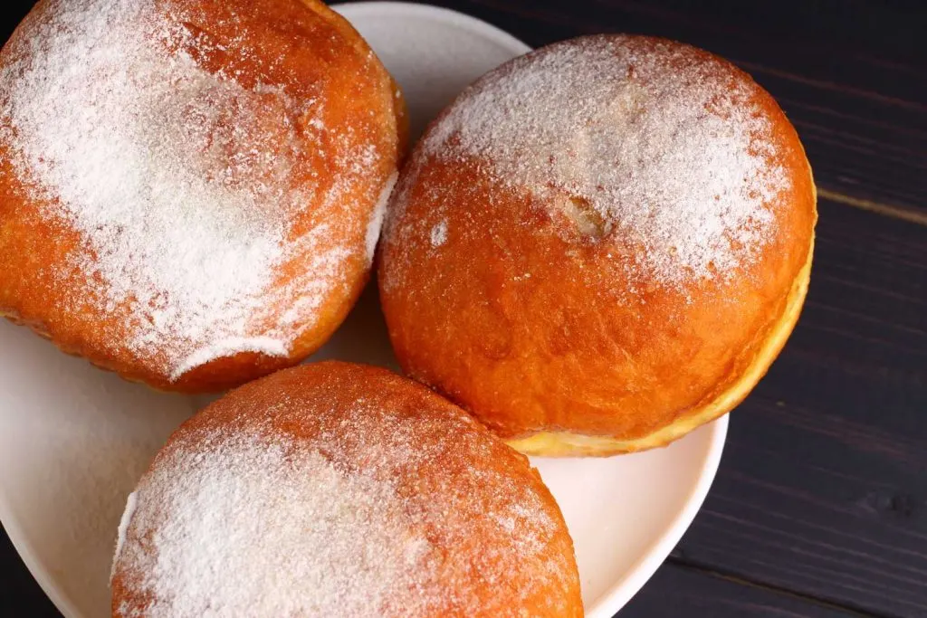 Sweet Pampushky (Солодкі пампушки) – Ukrainian Doughnuts served with powdered sugar on top.