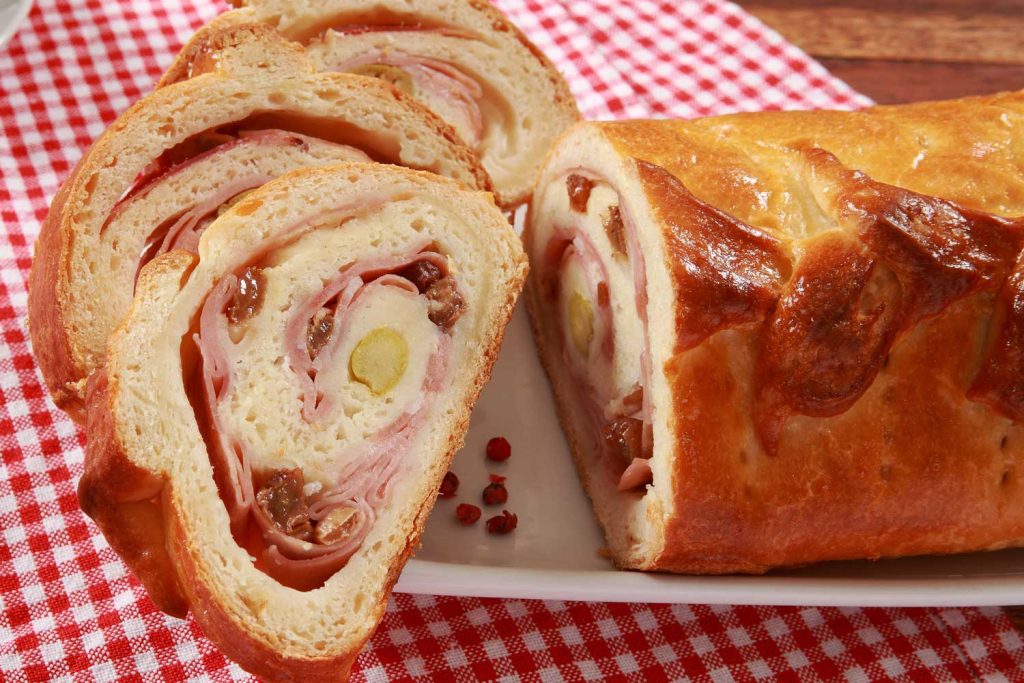 Pan de Jamón (Ham Bread) sliced and whole on the table.