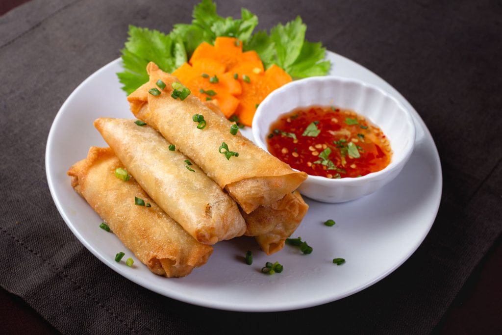 Fried Spring Rolls with chili sauce on a white plate.