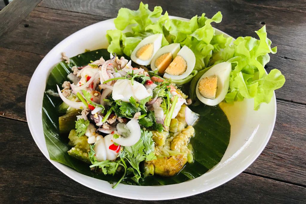 Grilled eggplant salad in a white bowl.