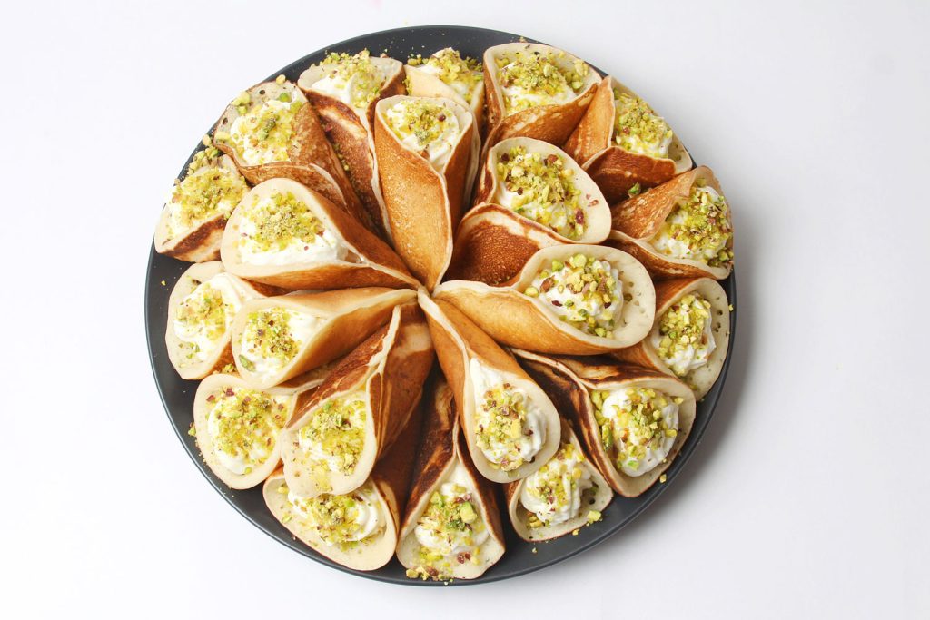 A plate of qatayef filled with cream and nuts.