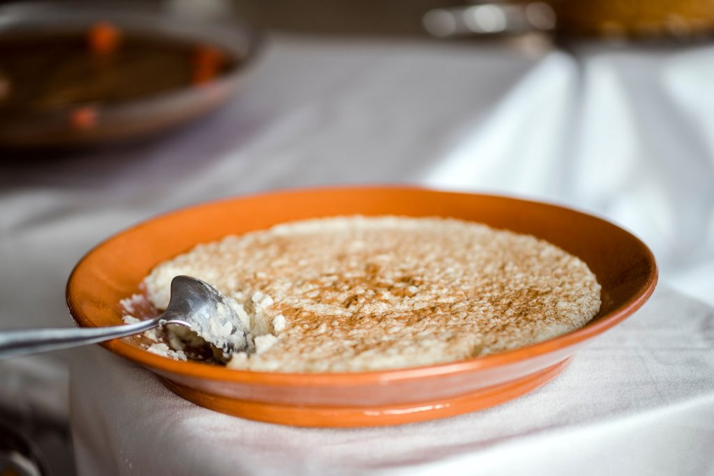 A bowl of arroz doce on the table.