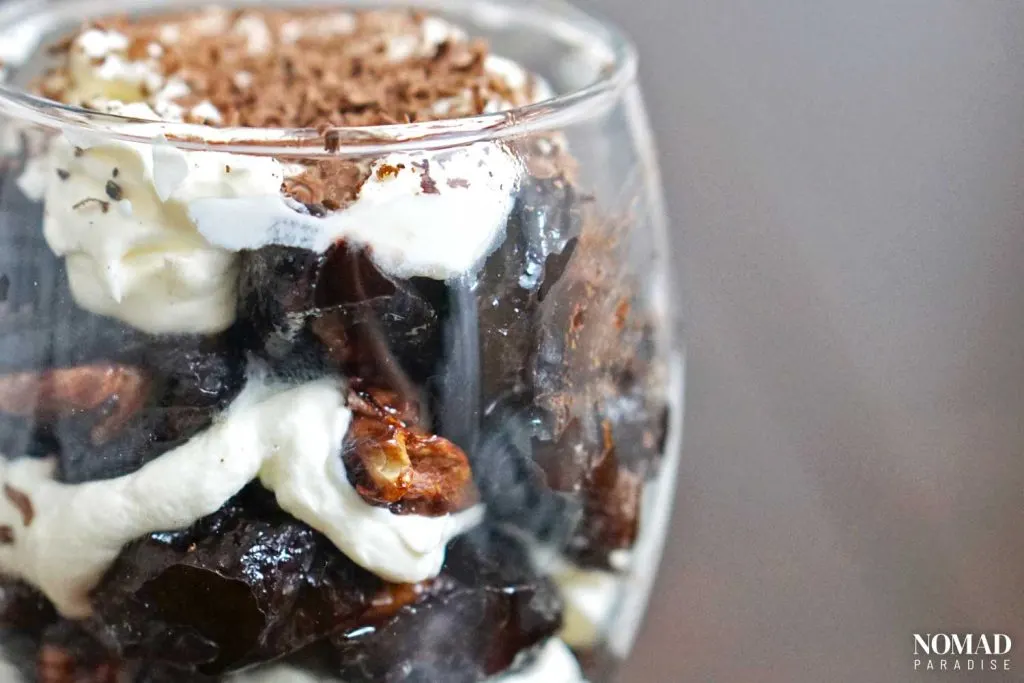 Walnut-stuffed prunes with whipped cream in a glass.