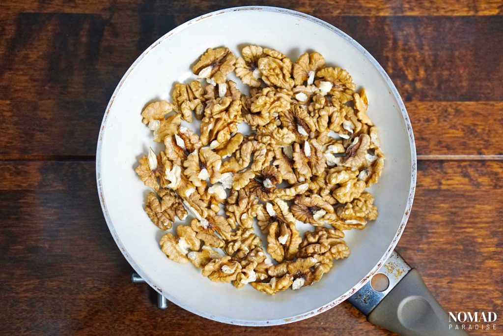 Muhammara recipe step by step (toasted walnuts in small pan).