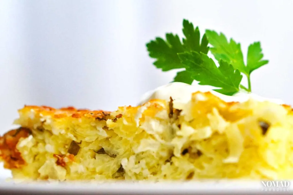 Patatnik, topped with sour cream and parsley.