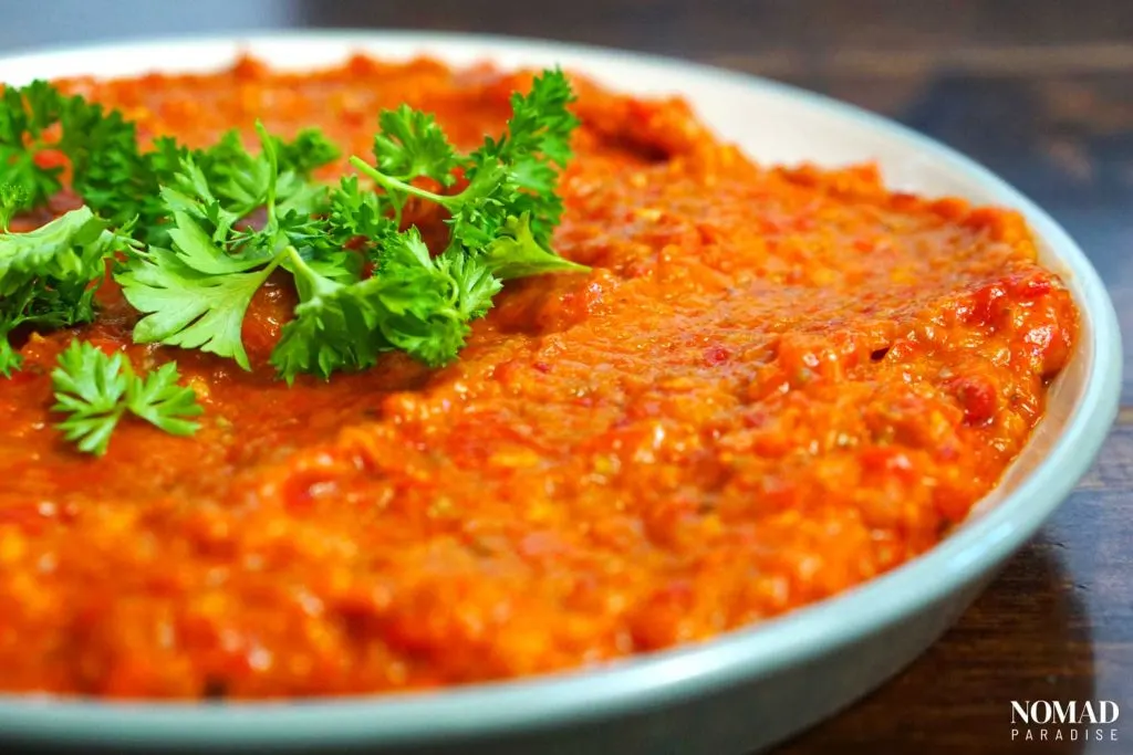 Ajvar on a small plate, topped with parsley.