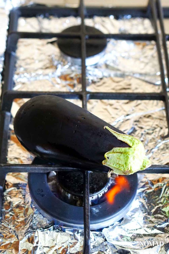 Charring the eggplant on the gas stove.