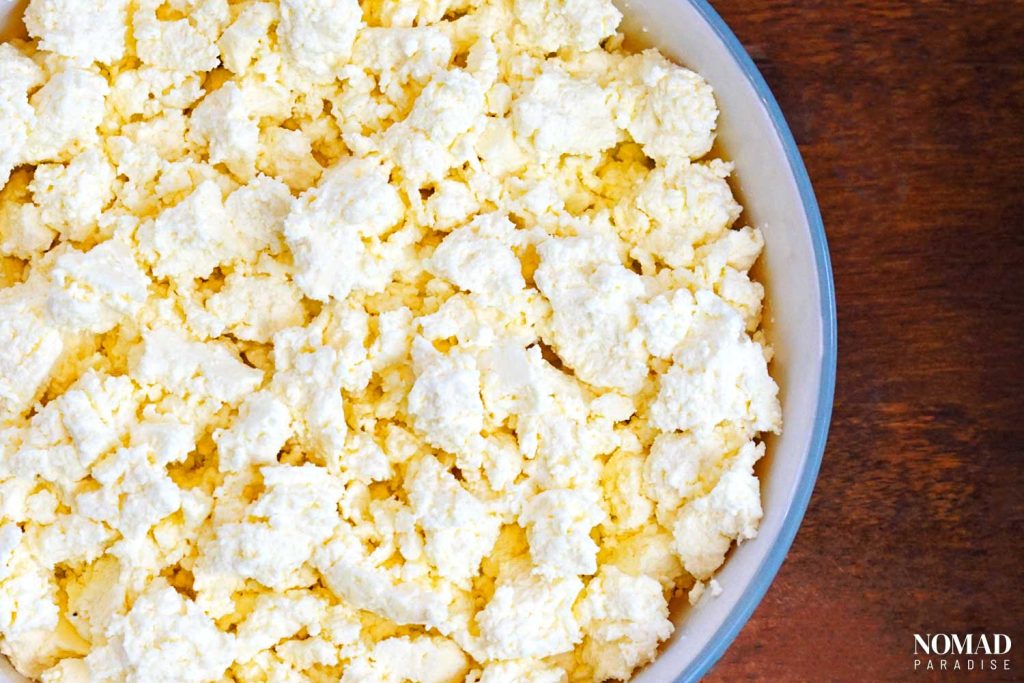 Homemade Farmer's Cheese Recipe (Tvorog) - crumbled, in a large bowl.