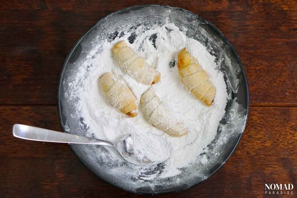 Cornulete Crescent Cookies Recipe Step by Step (rolling the cornulete in the powdered sugar).