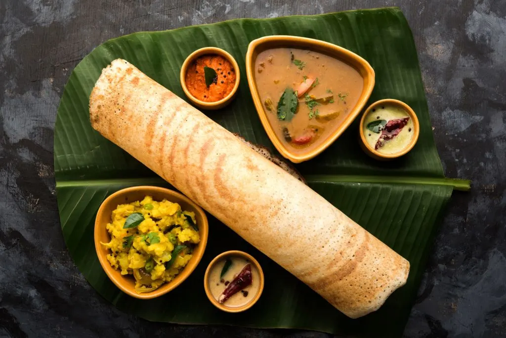 Dosa served with sambar and chutney.