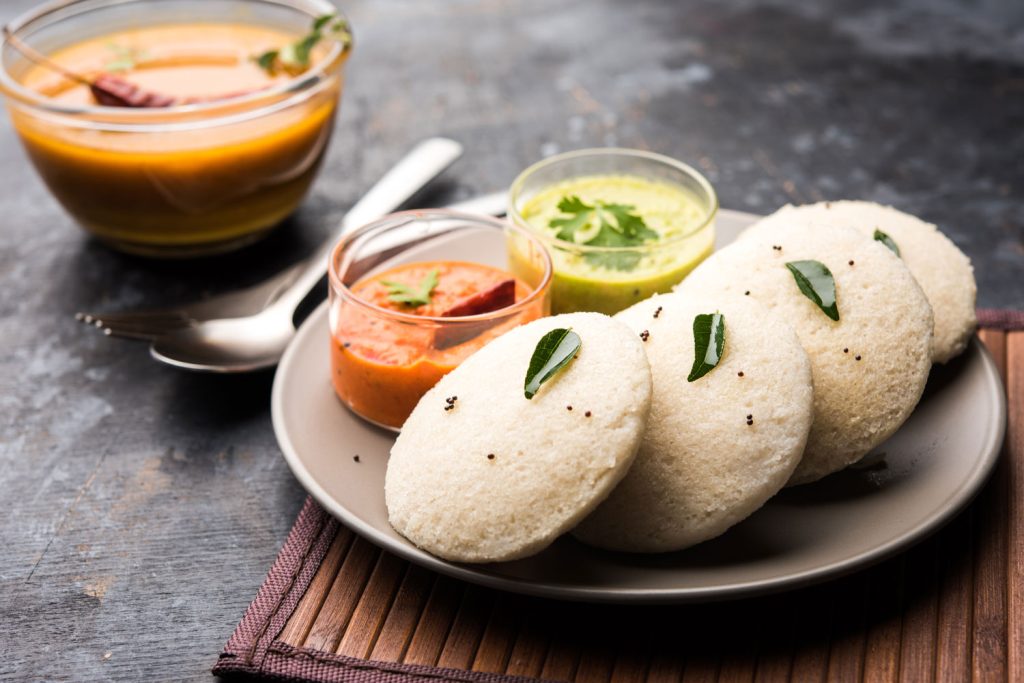 Idli with sambar and chutneys.