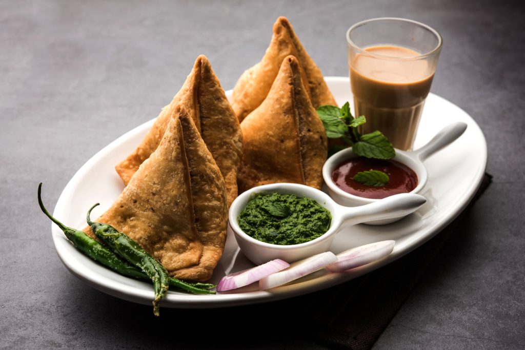 Samosas with chutney, ketchup and tea.