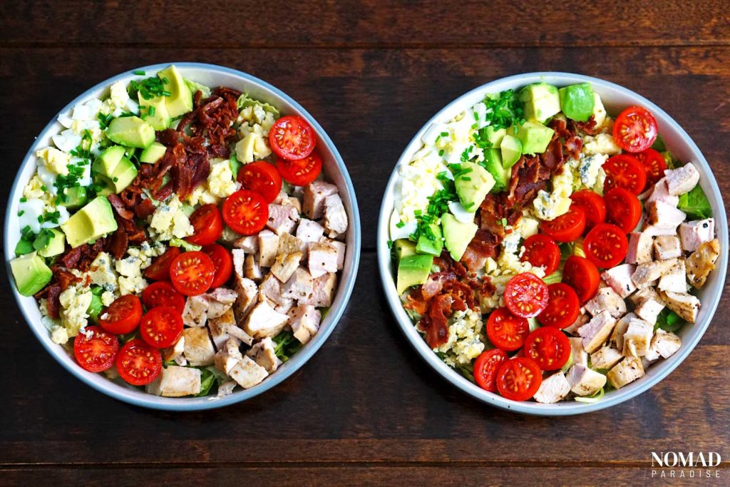 Cobb salad step-by-step (all ingredients arranged in rows over the salad greens in two large bowls).