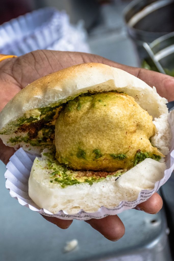Holding vada pav in a hand