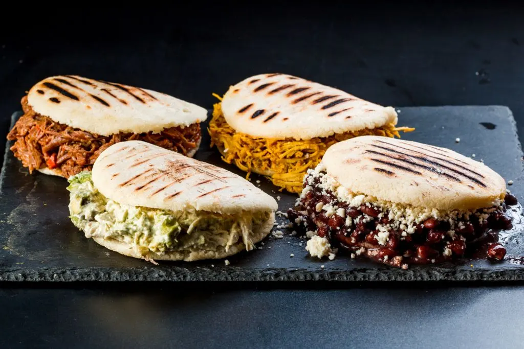 Stuffed arepas on a serving board.