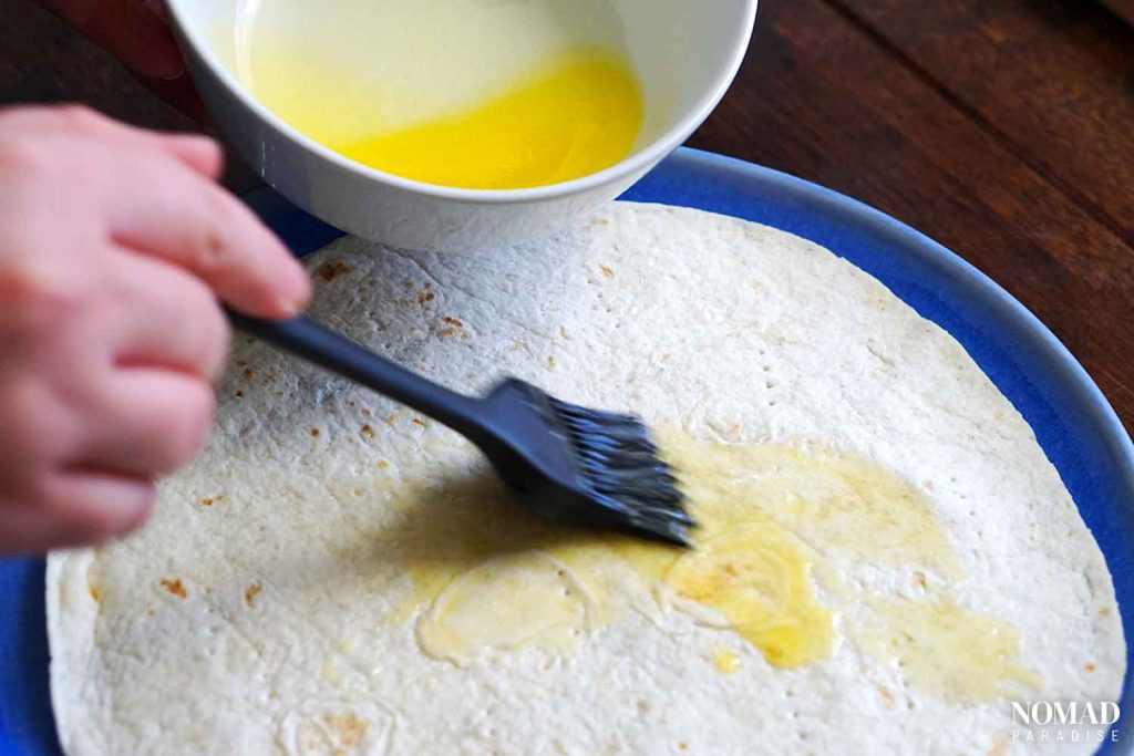 brushing tortillas with melted butter