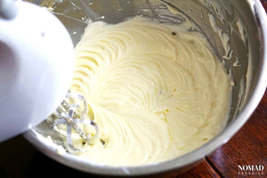 Irish potato candy step by step (mixture of softened butter, cream cheese, vanilla, and icing sugar in a mixing bowl).