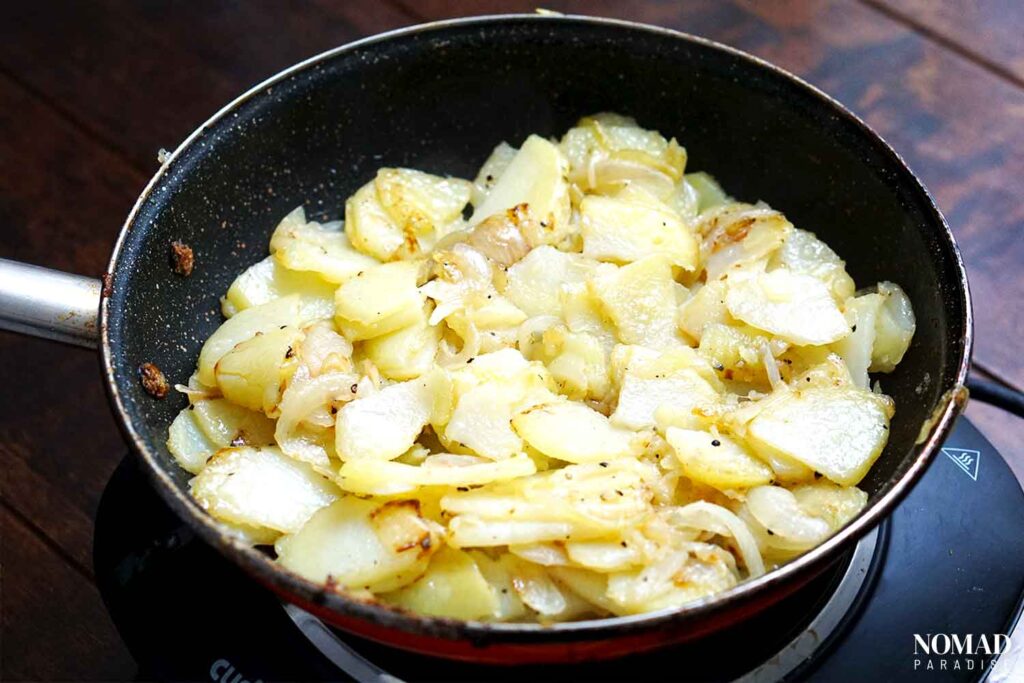 Tortilla Espanola recipe step-by-step (cooking the potatoes and onions).