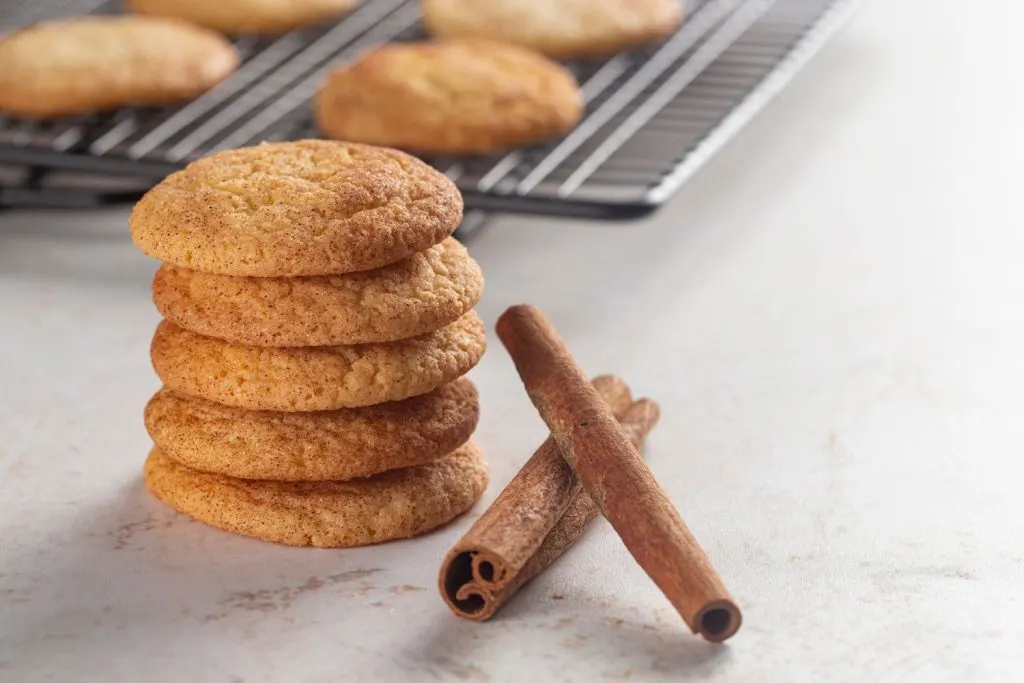 Snickerdoodle cookies and cinnamon sticks on a kitchen countertop