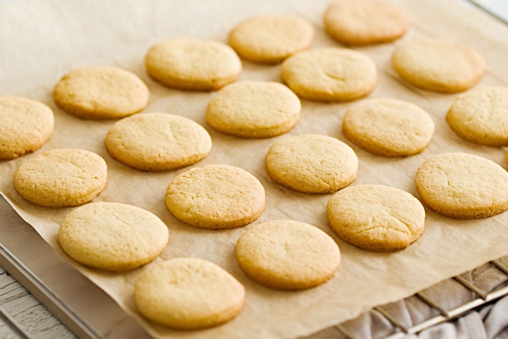 Butter cookies on baking paper on a cooling rack
