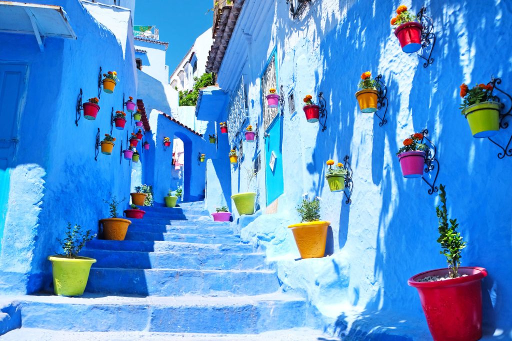Blue stairs and houses with colorful flowers in Chefchaouen, Morocco