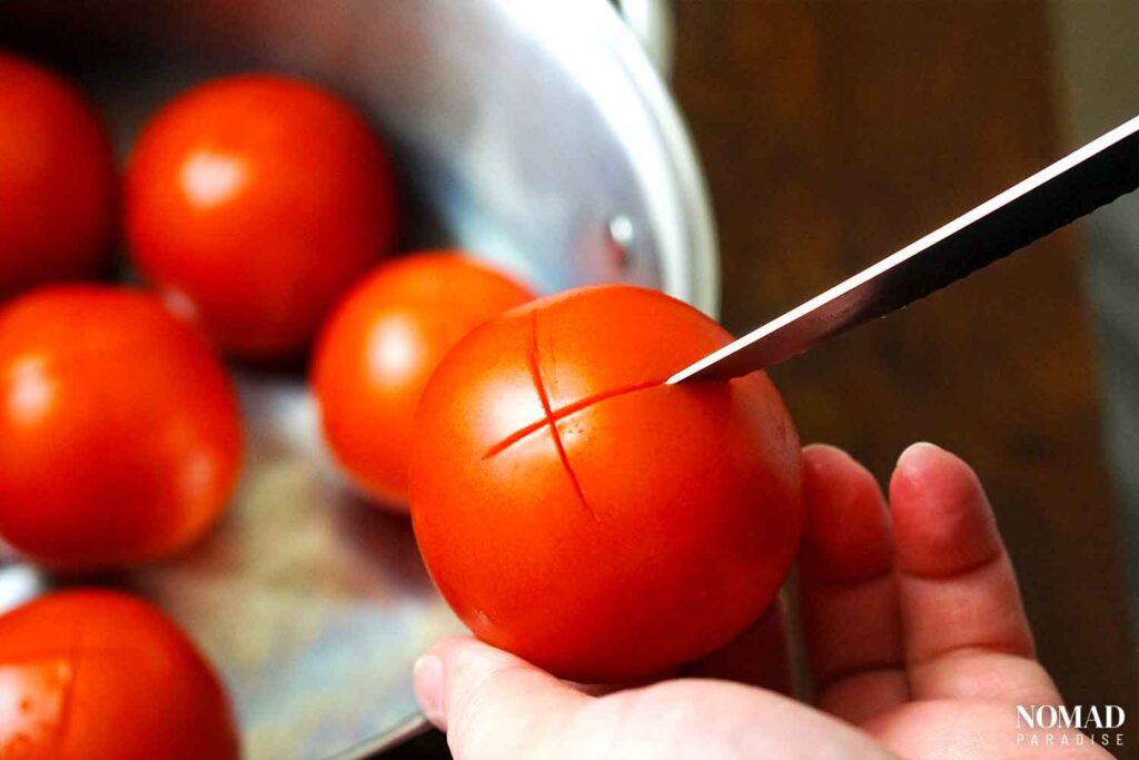 Making an x on the bottom of the tomatoes for easier peeling.