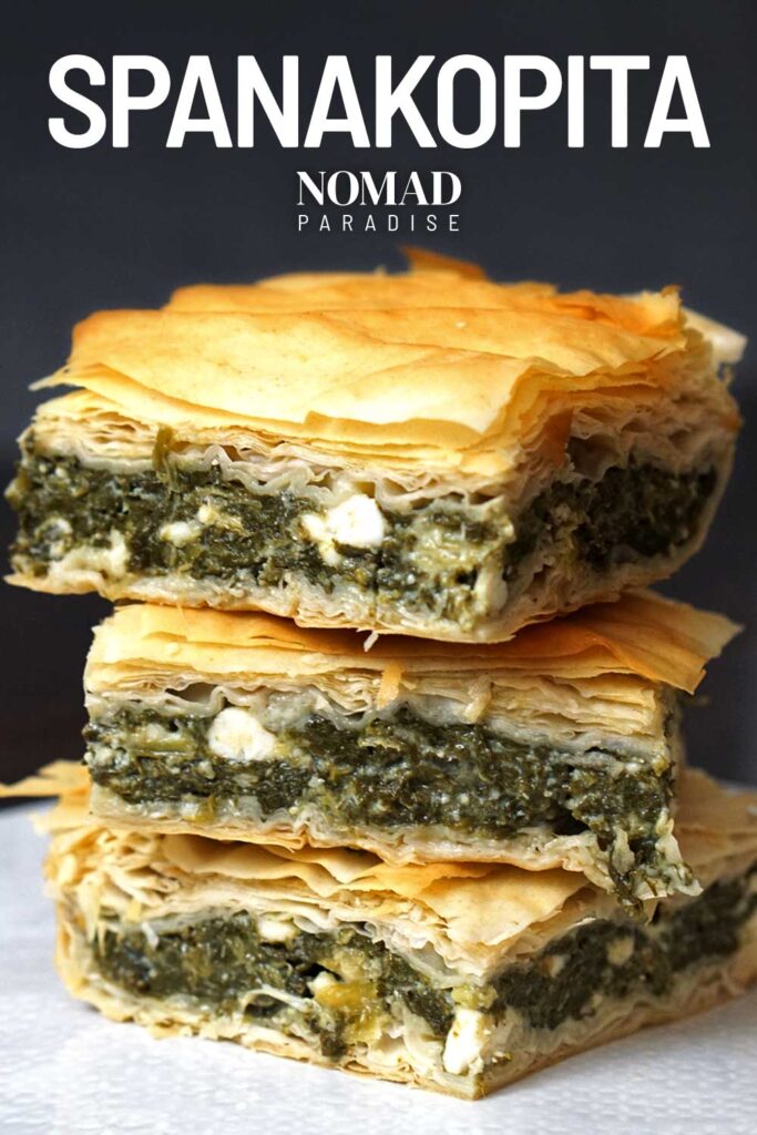 Spanakopita squares stacked on a plate.