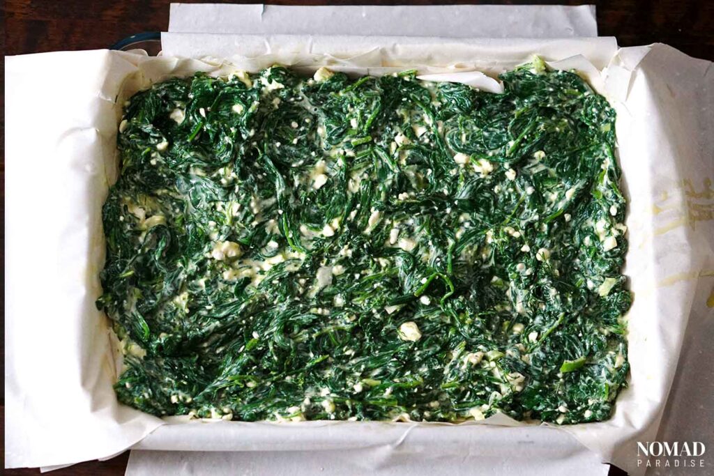 Spanakopita recipe step-by-step (adding the spinach-feta filling).
