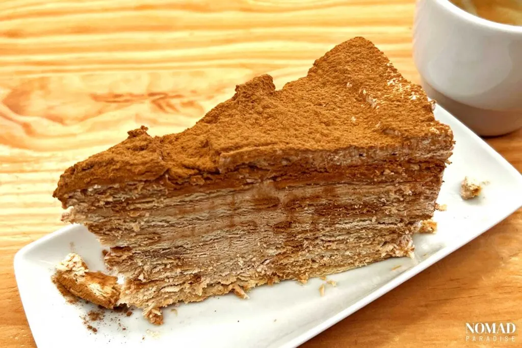 A slice of Bolo de Bolacha with coffee