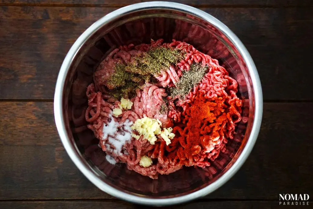 Romanian Meat Rolls (Mici or Mititei) recipe step-by-step (mixing the meat with the spices).
