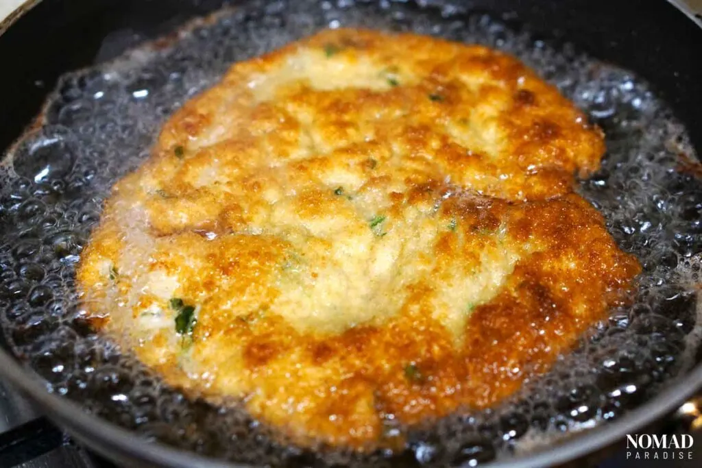 Frying the milanesa on the second side.