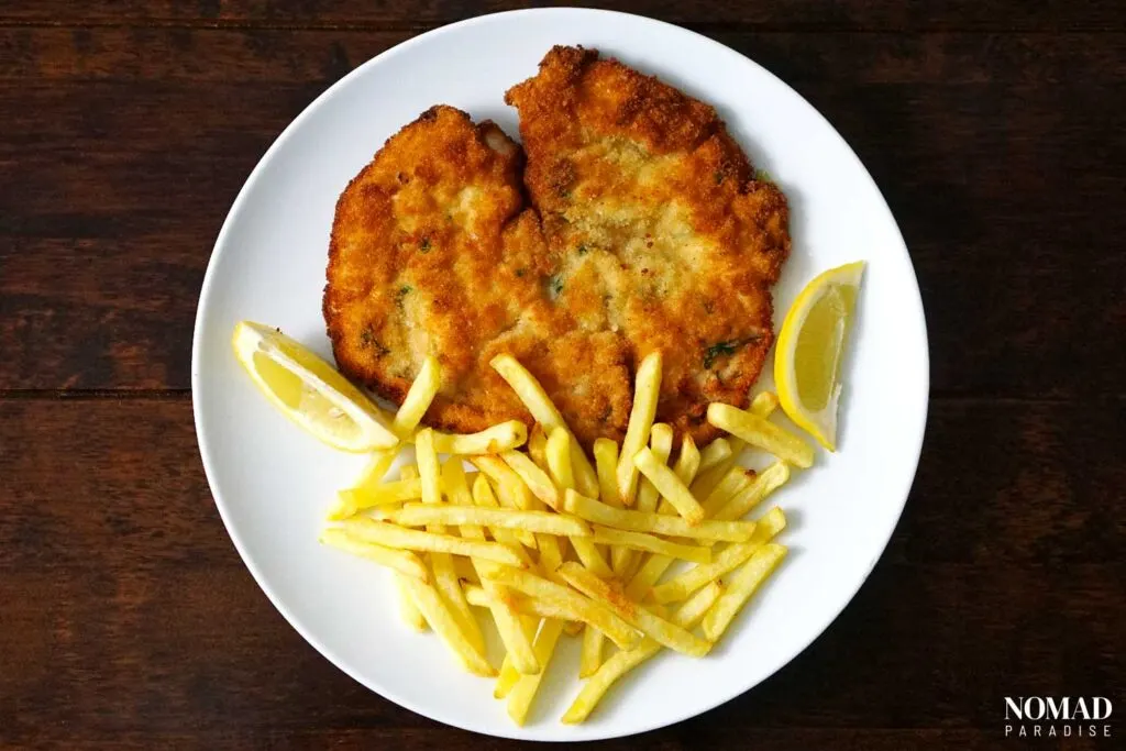 Milanesa with fries and lemon slices.