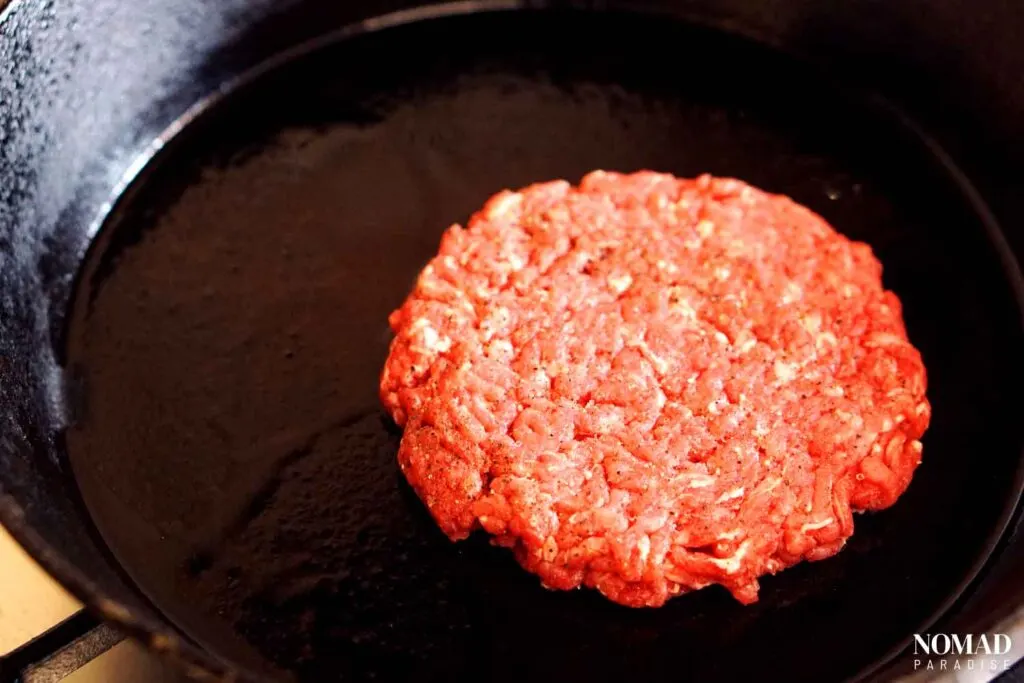 Burger patty in a cast iron pan