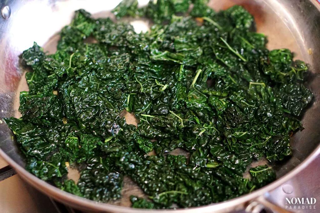 Sauteeing kale in a pan.